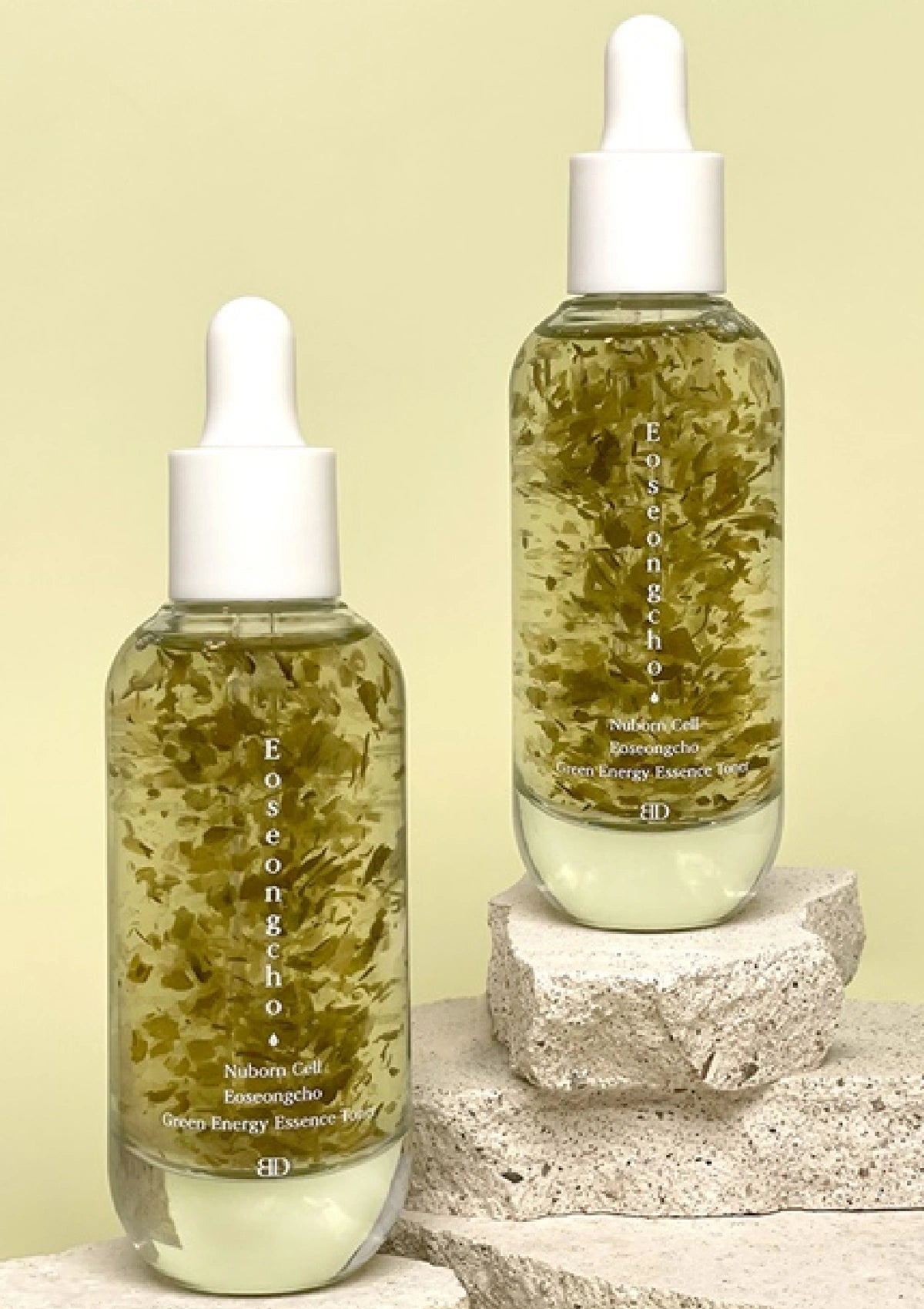 Two bottles of Eoseongcho skincare product on a stone surface with a light green background